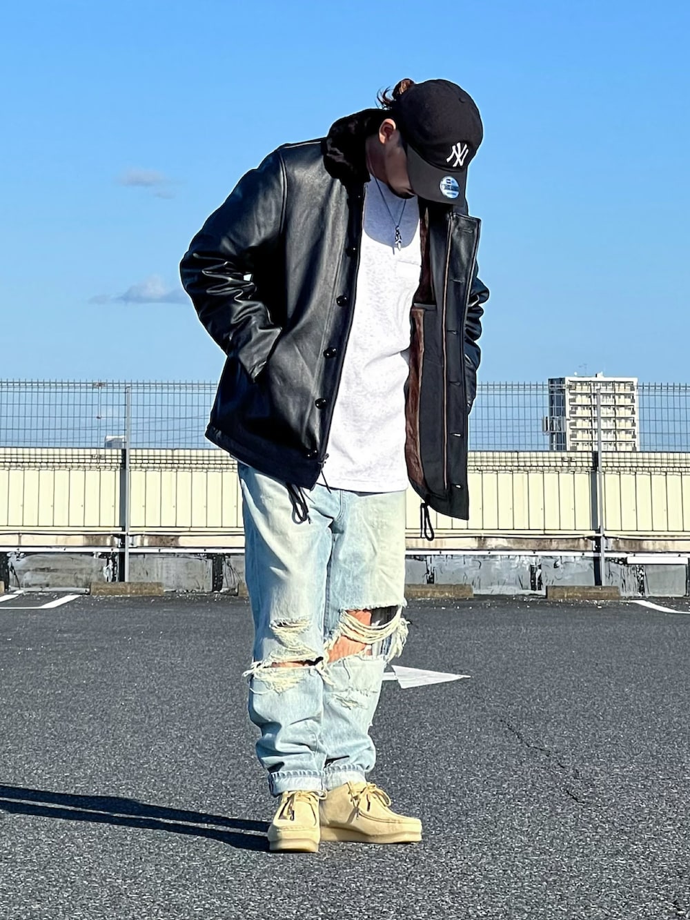 ブラック系のミリタリージャケット、ベージュ系のモカシン/デッキシューズ、ブルー系のデニムパンツを着用したメンズの秋コーディネートの2枚目の写真