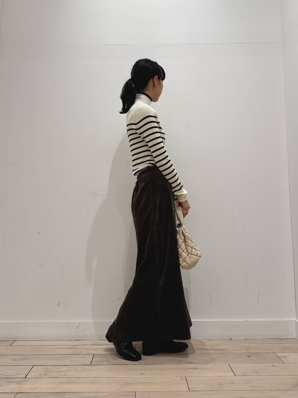 ホワイト系のニット/セーター、ブラウン系のスカート、ホワイト系のハンドバッグを着用したレディースの秋コーディネートの3枚目の写真