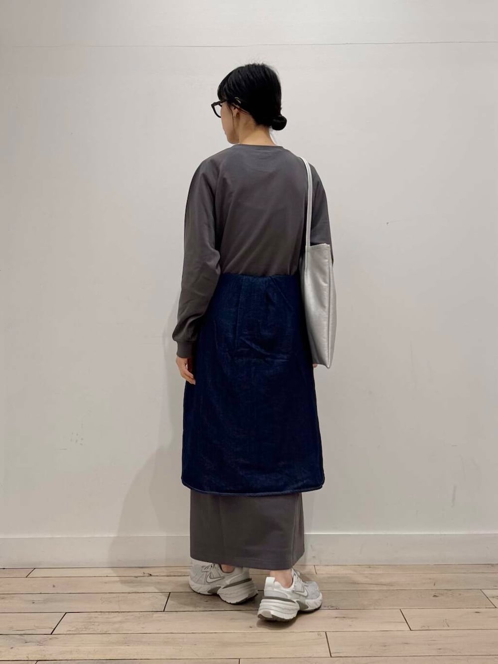 シルバー系のスニーカー、ブルー系のシャツ/ブラウス、シルバー系のトートバッグを着用したレディースの春コーディネートの3枚目の写真