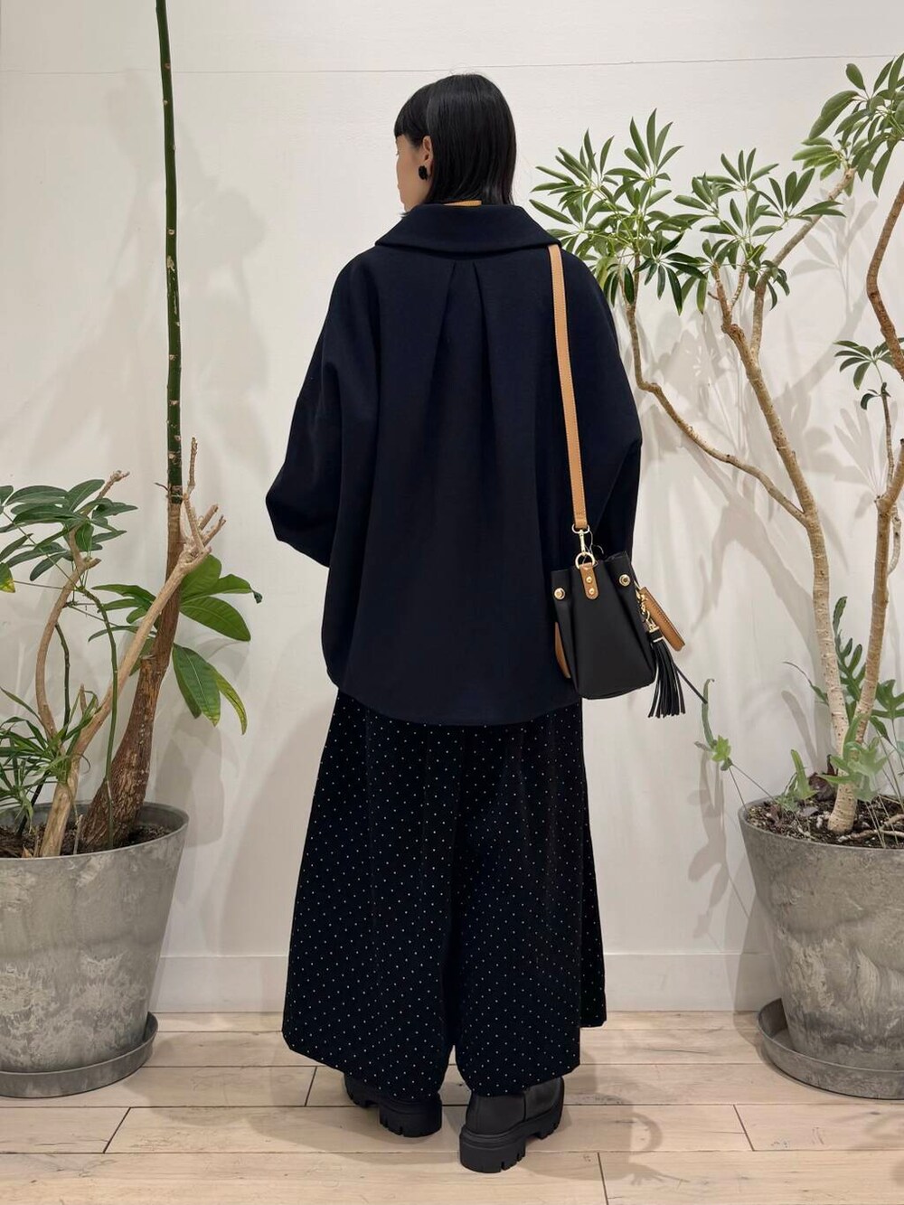 ブラック系のトートバッグ、イエロー系のニット/セーター、ブルー系のその他アウターを着用したレディースの秋コーディネートの3枚目の写真