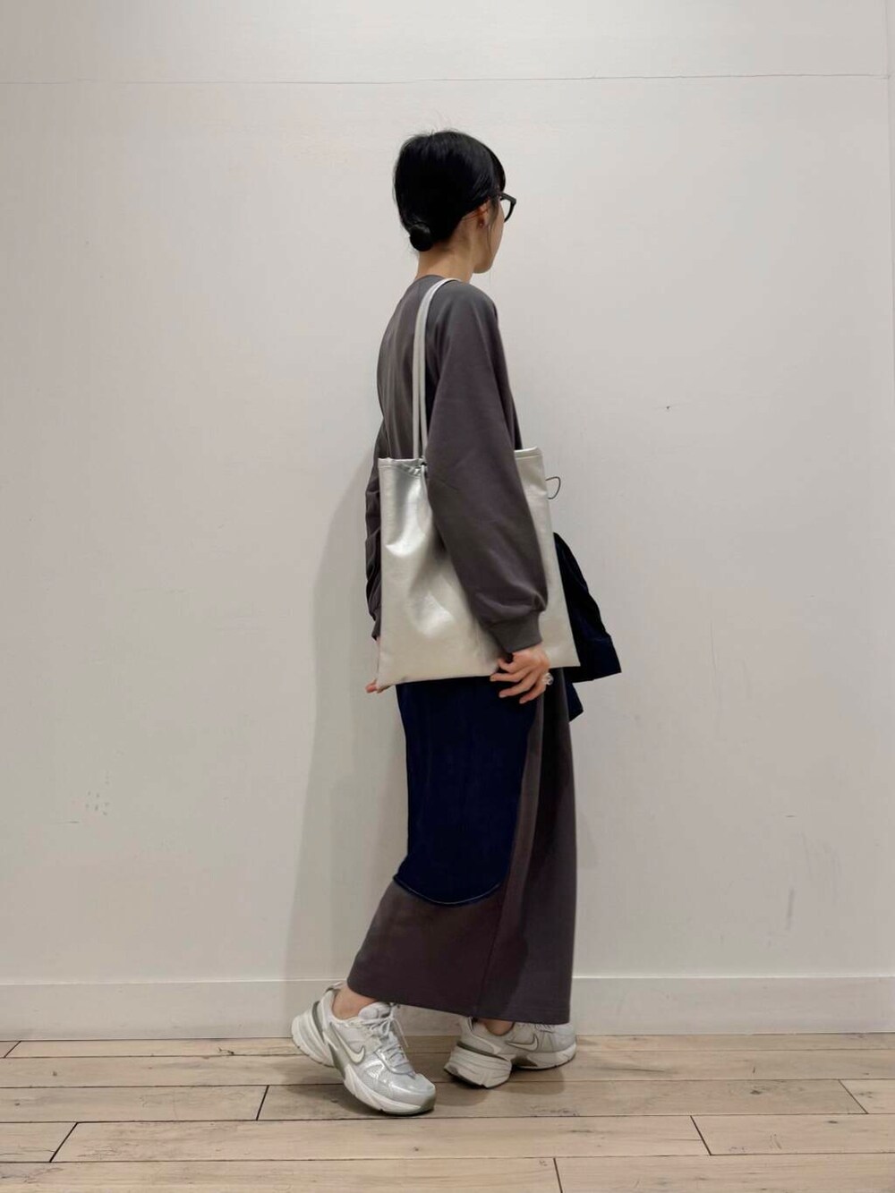 シルバー系のスニーカー、ブルー系のシャツ/ブラウス、シルバー系のトートバッグを着用したレディースの春コーディネートの2枚目の写真