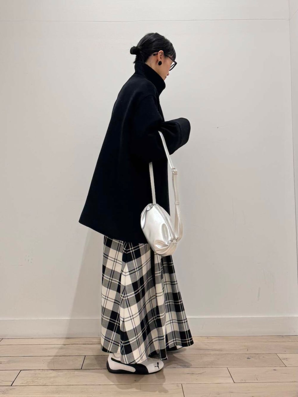 ブラック系のその他アウター、ホワイト系のスウェット、ホワイト系のスカートを着用したレディースの冬コーディネートの2枚目の写真