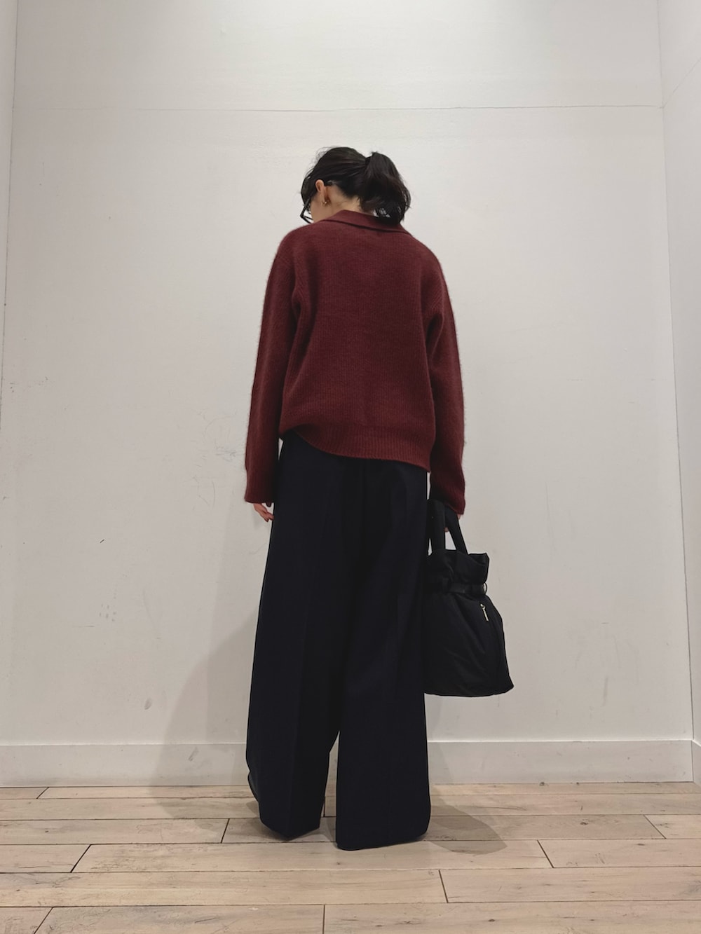 レッド系のニット/セーター、ブルー系のその他パンツ、ブラック系のブーツを着用したレディースの秋コーディネートの3枚目の写真