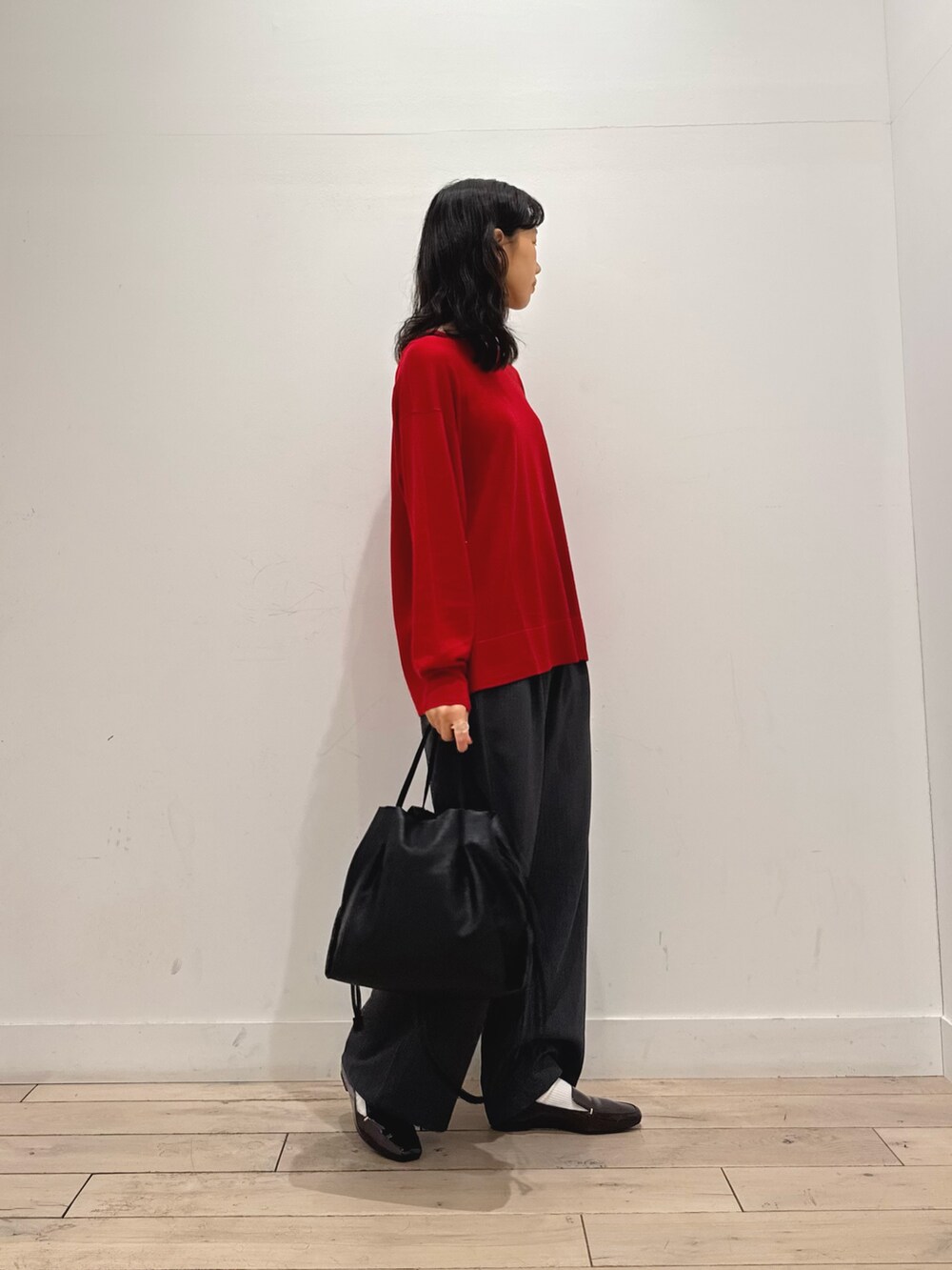 レッド系のニット/セーター、グレー系のその他パンツ、ブラウン系のローファーを着用したレディースの秋コーディネートの2枚目の写真