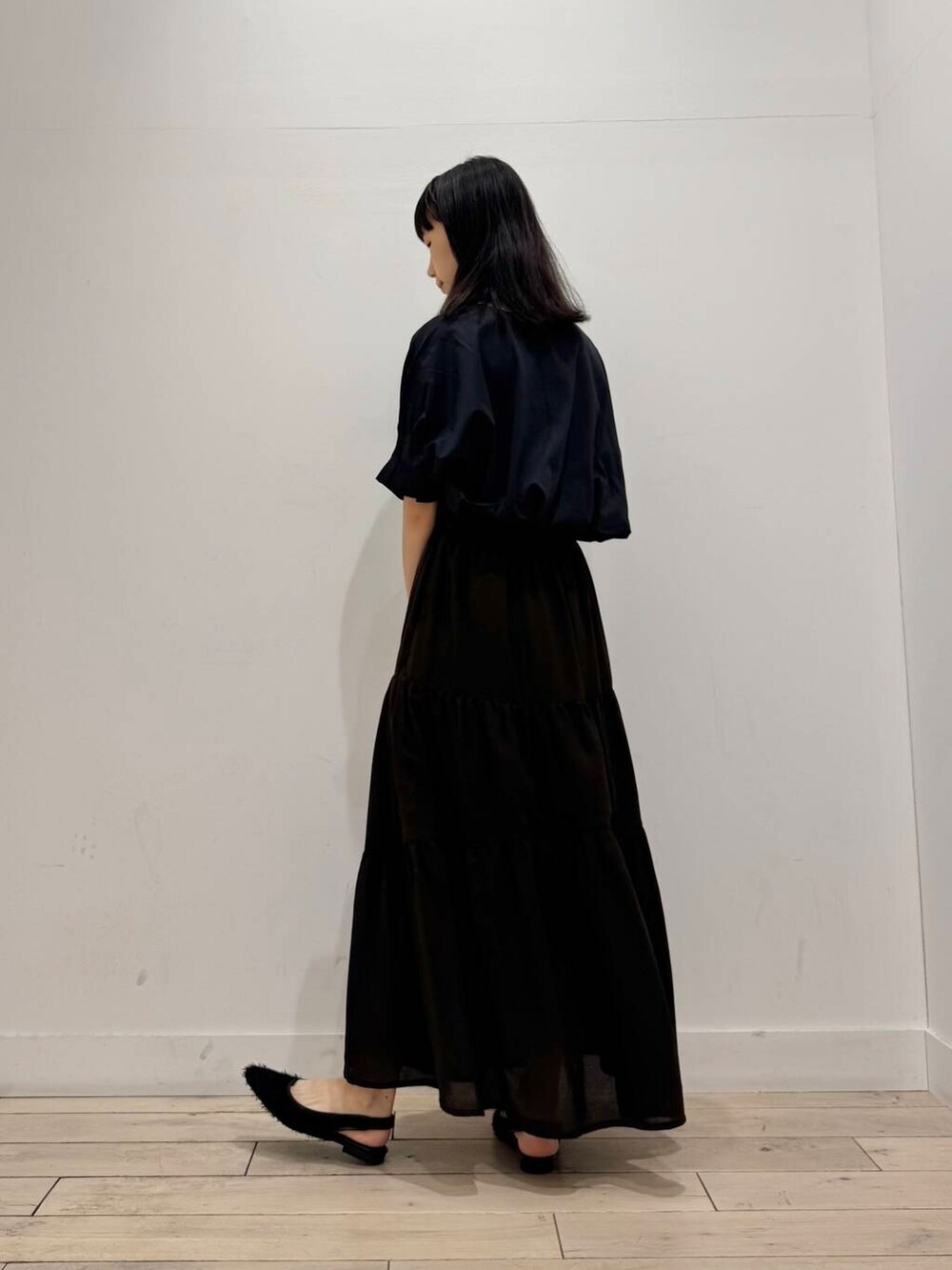 ブラック系のショルダーバッグ、ブラック系のTシャツ/カットソー、ブラウン系のスカートを着用したレディースの夏コーディネートの4枚目の写真