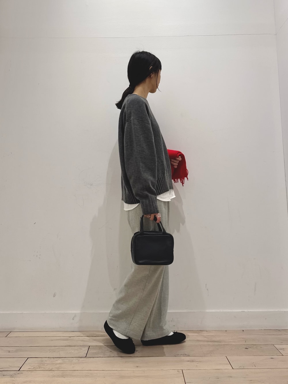 グレー系のニット/セーター、ホワイト系のTシャツ/カットソー、グレー系のその他パンツを着用したレディースの秋コーディネートの2枚目の写真