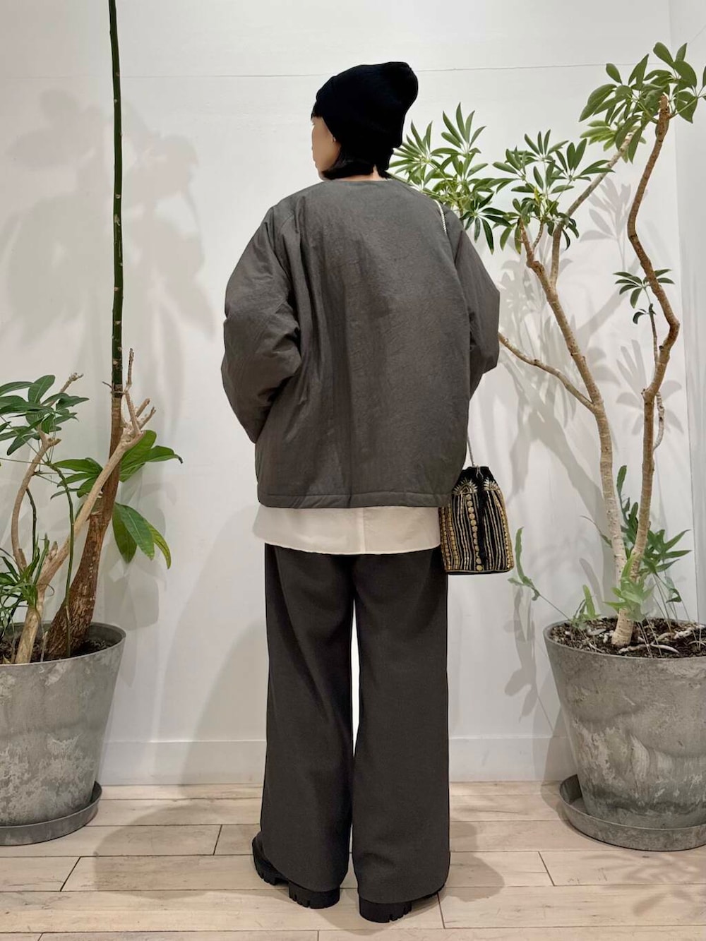 ブラック系のショルダーバッグ、ブラック系のブーツ、グレー系のその他パンツを着用したレディースの秋コーディネートの3枚目の写真