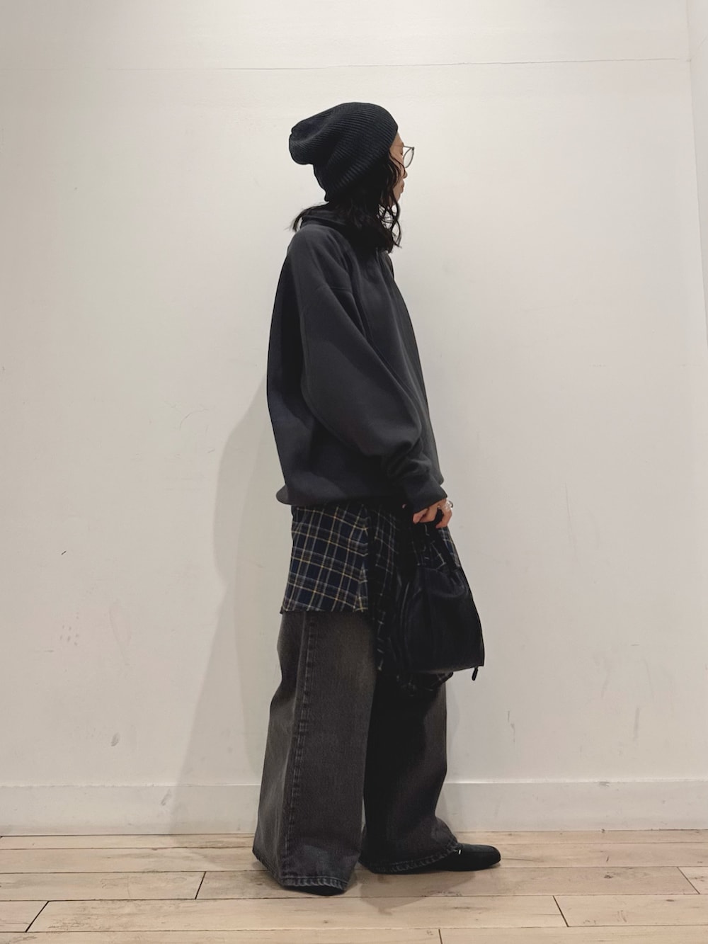 グレー系のスウェット、ブラック系のデニムパンツ、ブラック系のショルダーバッグを着用したレディースの秋コーディネートの2枚目の写真
