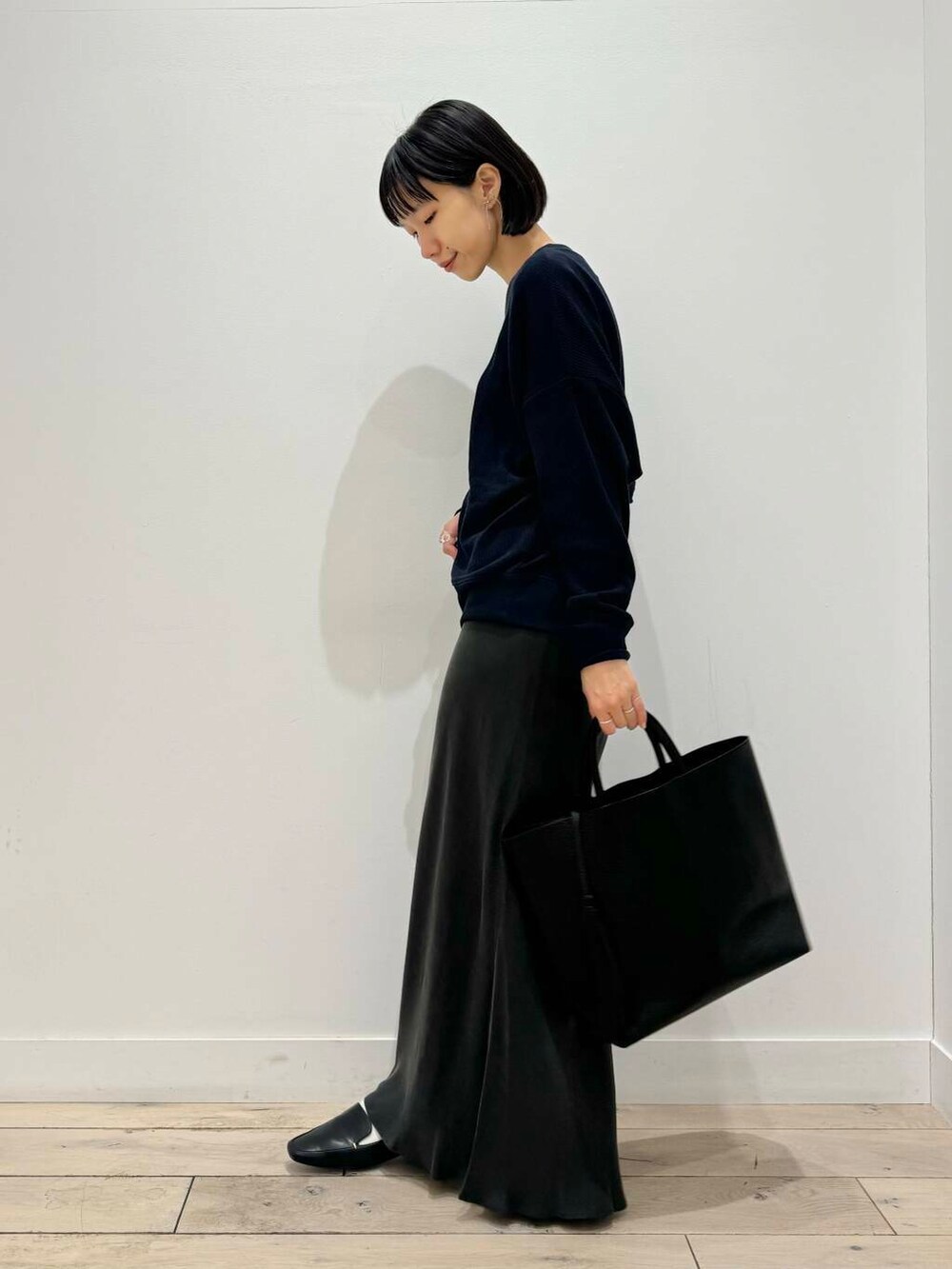 ブラック系のローファー、ブラック系のトートバッグ、ブルー系のTシャツ/カットソーを着用したレディースの夏コーディネートの4枚目の写真