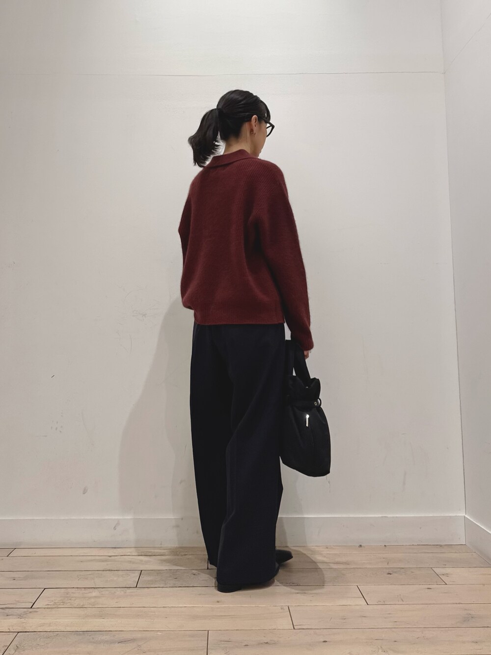 レッド系のニット/セーター、ブルー系のその他パンツ、ブラック系のブーツを着用したレディースの秋コーディネートの2枚目の写真