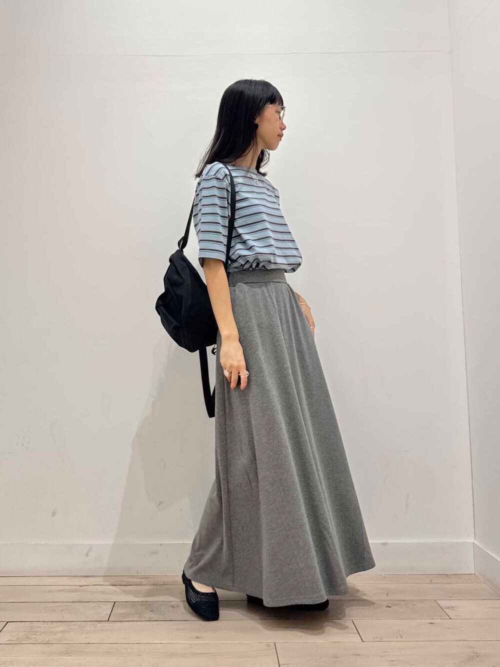 ブラック系のバックパック/リュック、グレー系のスカート、ブラック系のバレエシューズを着用したレディースの夏コーディネートの2枚目の写真