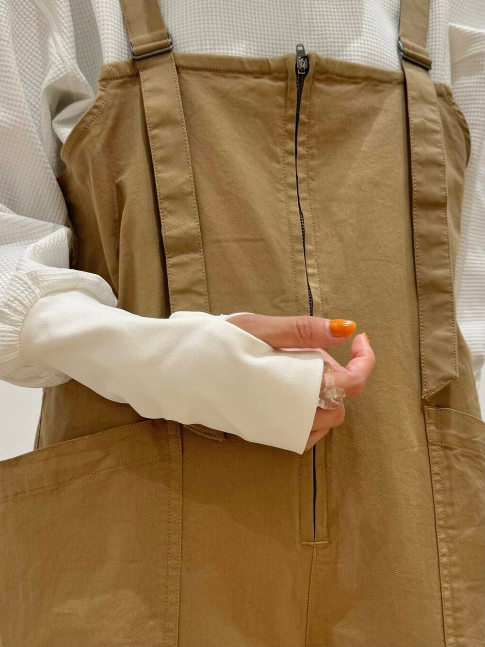 イエロー系のサロペット/オーバーオール、ホワイト系のスニーカー、ホワイト系のTシャツ/カットソーを着用したレディースの秋コーディネートの5枚目の写真