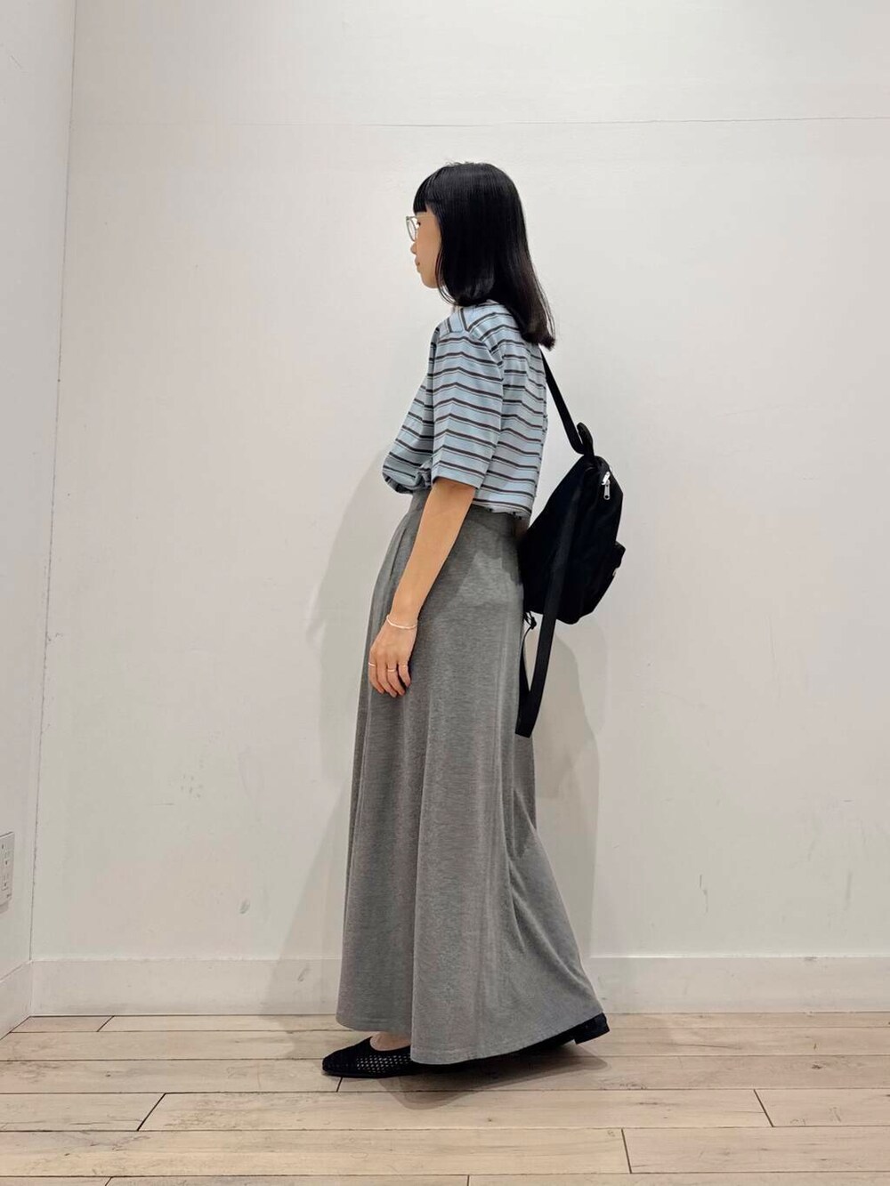 ブラック系のバックパック/リュック、グレー系のスカート、ブラック系のバレエシューズを着用したレディースの夏コーディネートの5枚目の写真