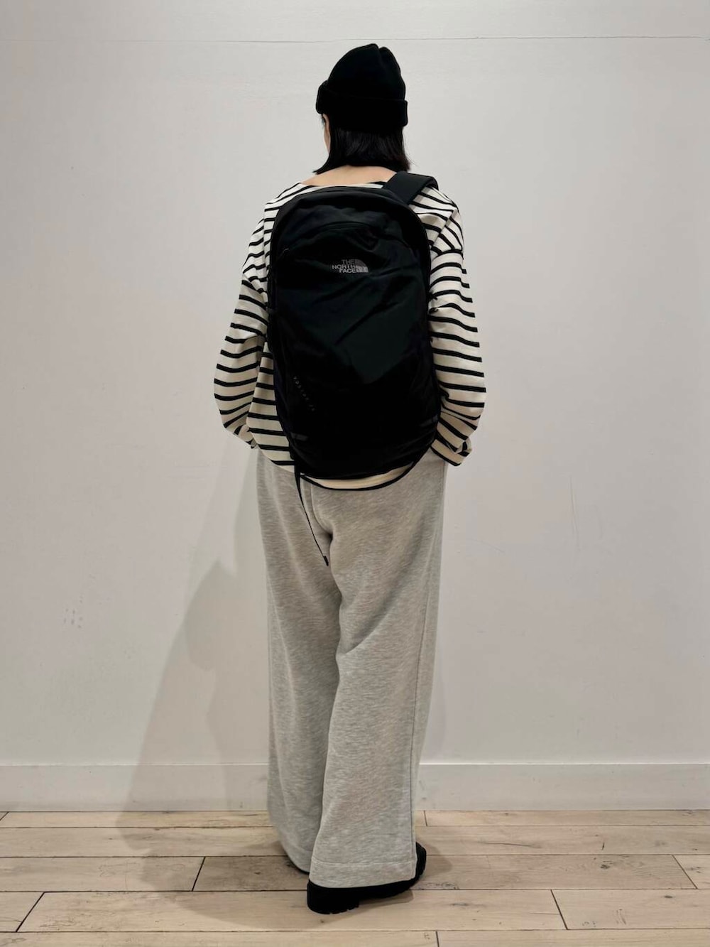 ブラック系のブーツ、ホワイト系のTシャツ/カットソー、ブラック系のバックパック/リュックを着用したレディースの秋コーディネートの3枚目の写真