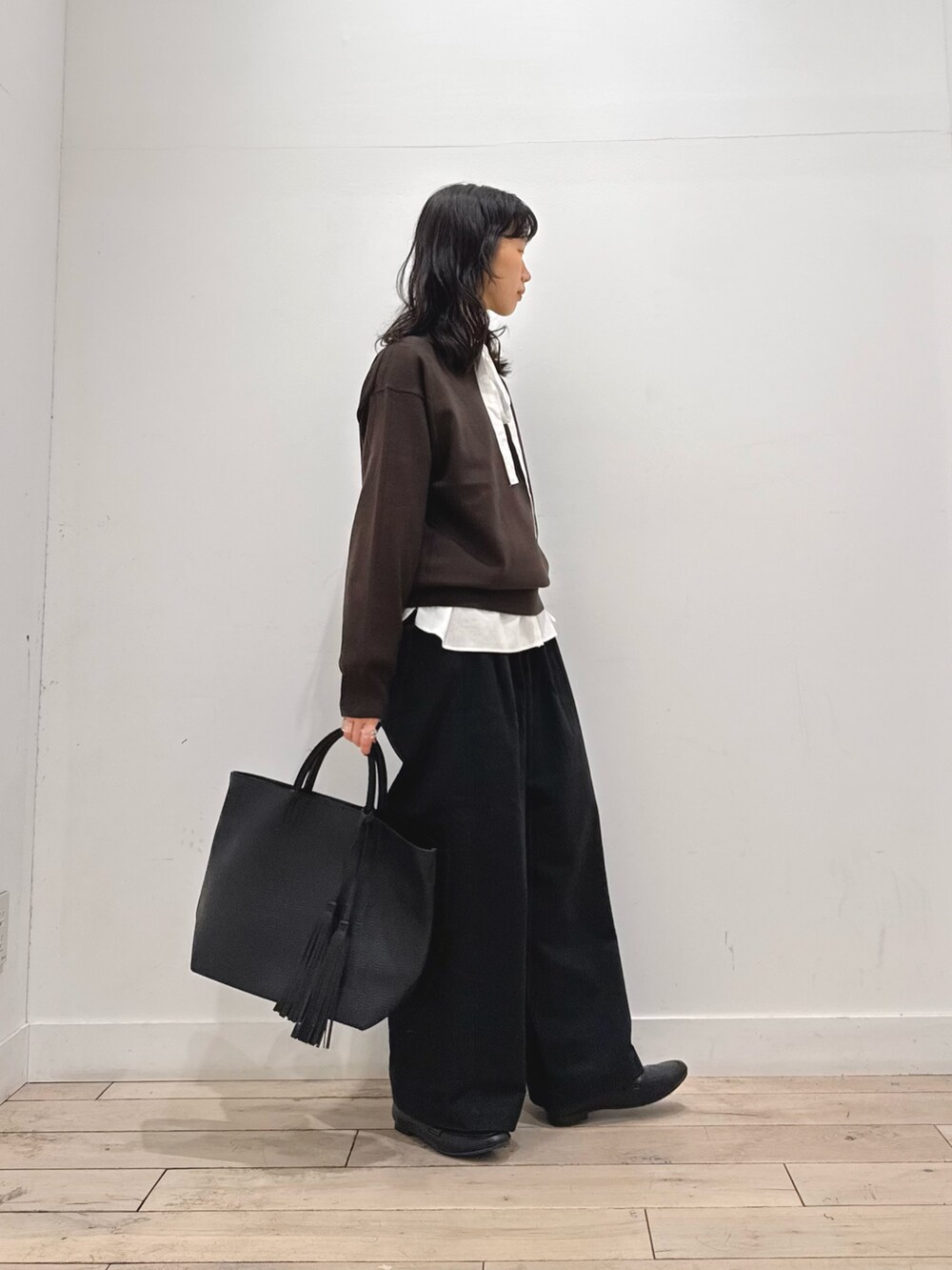 ホワイト系のシャツ/ブラウス、ブラウン系のニット/セーター、ブラック系のその他パンツを着用したレディースの秋コーディネートの2枚目の写真