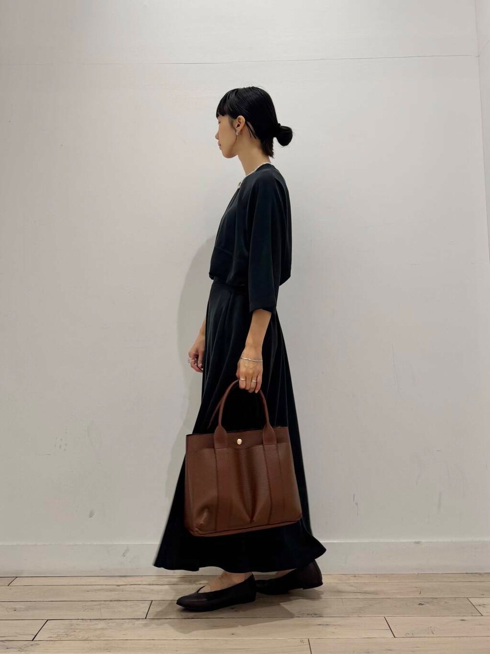 ブラウン系のパンプス、ブラック系のTシャツ/カットソー、ブラック系のスカートを着用したレディースの夏コーディネートの4枚目の写真