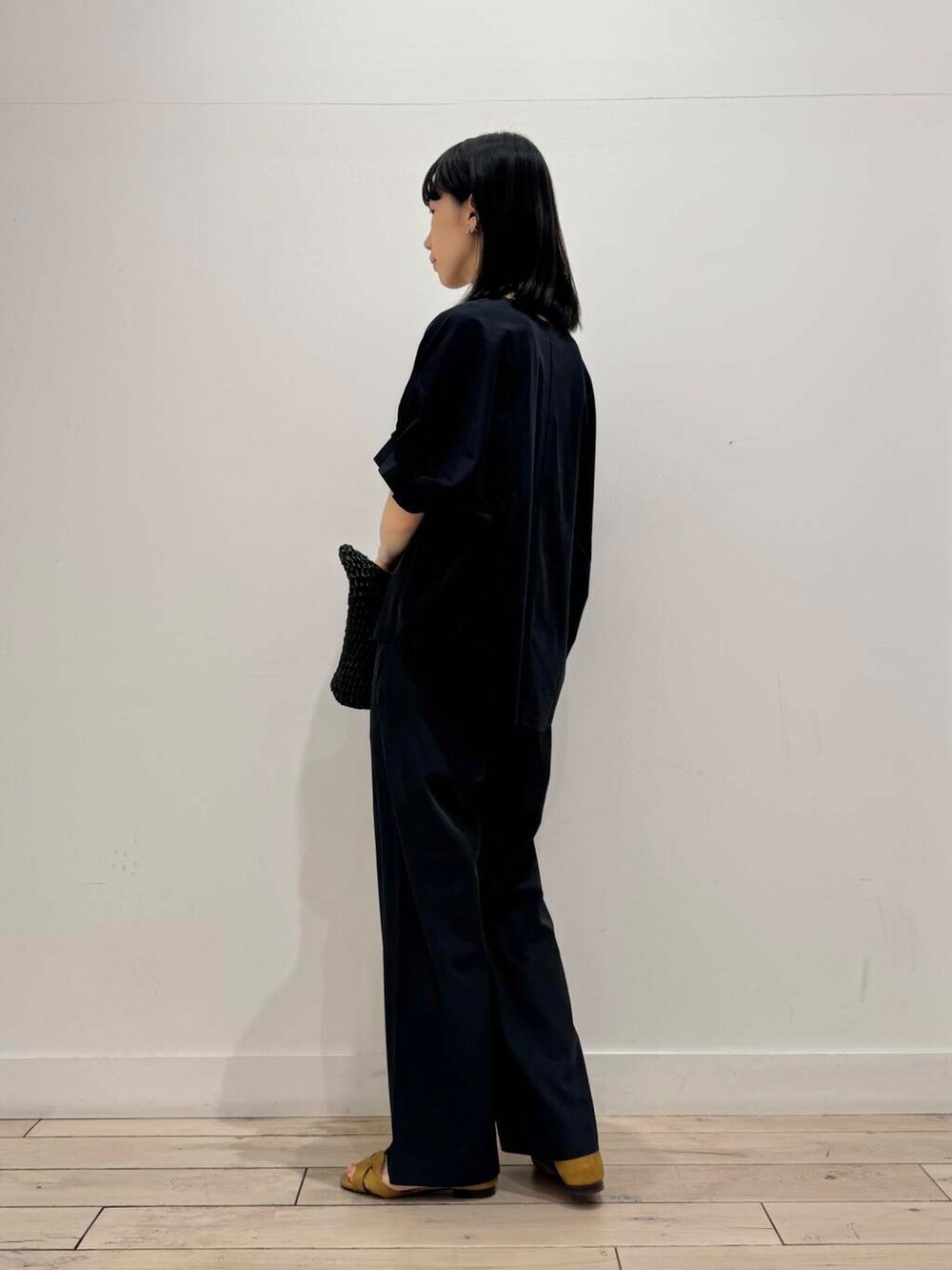 ブラック系のトートバッグ、イエロー系のサンダル、グレー系のその他パンツを着用したレディースの春コーディネートの4枚目の写真