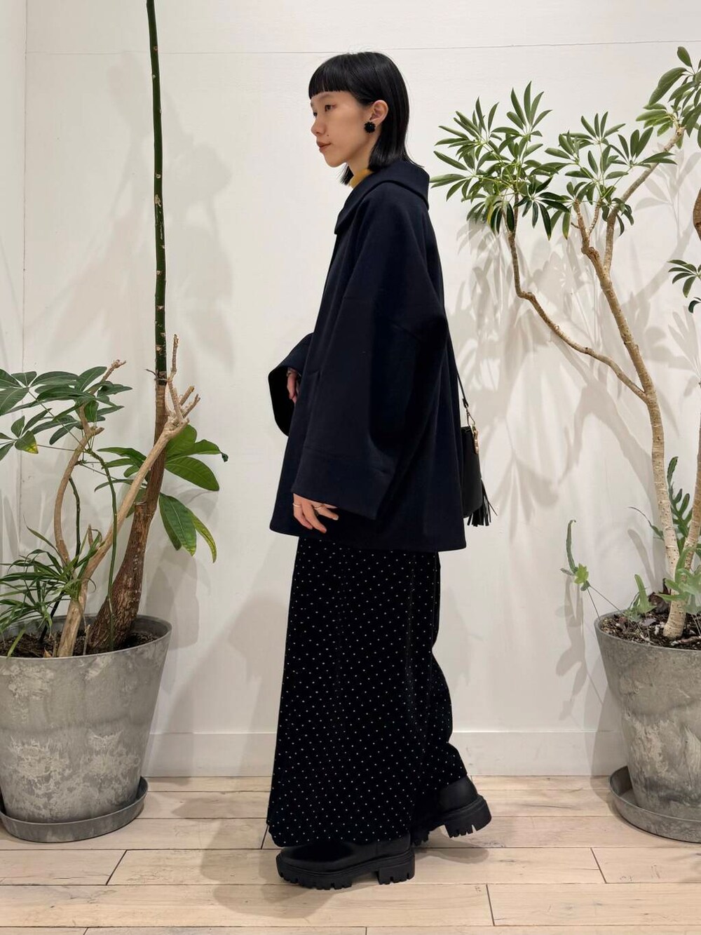 ブラック系のトートバッグ、イエロー系のニット/セーター、ブルー系のその他アウターを着用したレディースの秋コーディネートの2枚目の写真