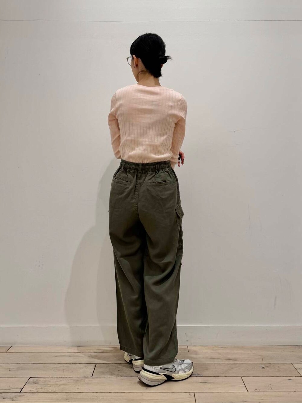 ホワイト系のスニーカー、イエロー系のハンドバッグ、ピンク系のTシャツ/カットソーを着用したレディースの冬コーディネートの3枚目の写真