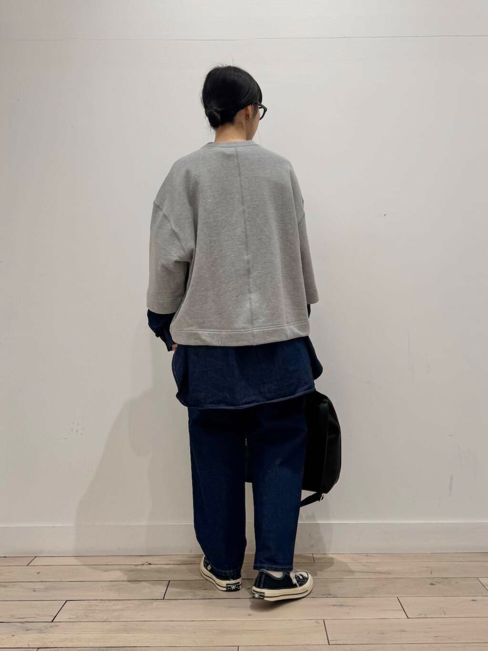 ブルー系のデニムパンツ、ブラック系のトートバッグ、ブルー系のシャツ/ブラウスを着用したレディースの春コーディネートの3枚目の写真