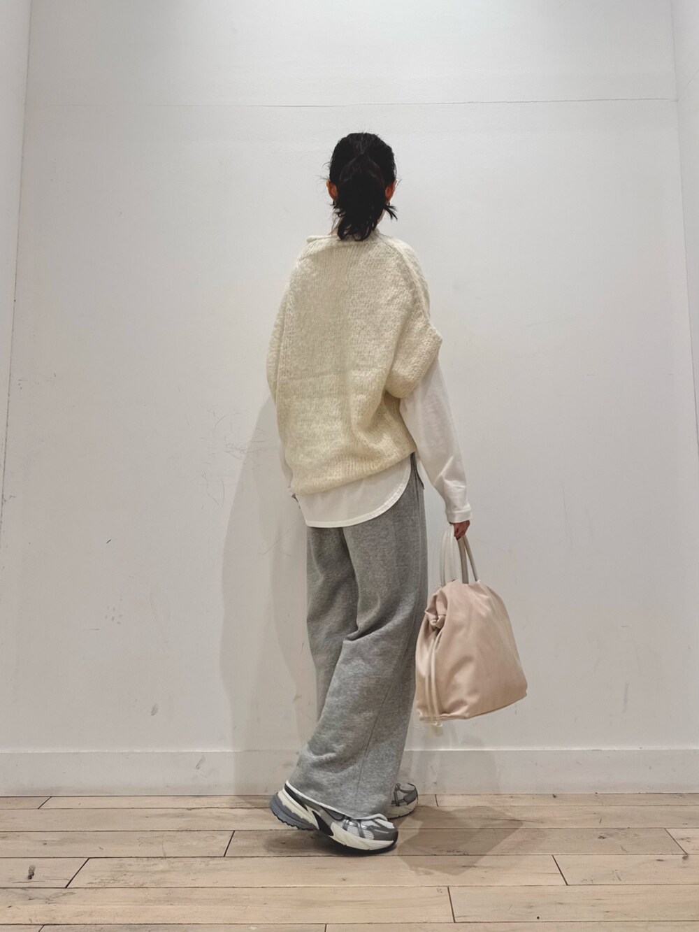 シルバー系のスニーカー、ホワイト系のショルダーバッグ、ホワイト系のニット/セーターを着用したレディースの秋コーディネートの3枚目の写真