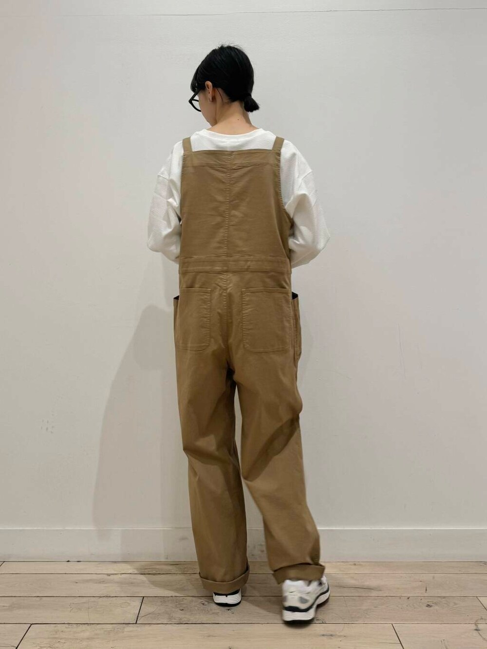 イエロー系のサロペット/オーバーオール、ホワイト系のスニーカー、ホワイト系のTシャツ/カットソーを着用したレディースの秋コーディネートの3枚目の写真