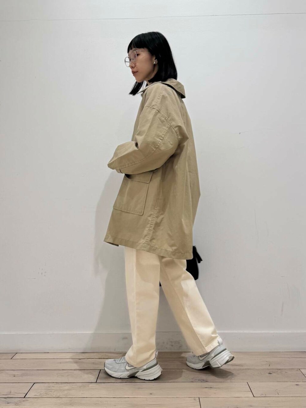 ブラック系のボストンバッグ、シルバー系のスニーカー、ベージュ系のデニムパンツを着用したレディースの冬コーディネートの5枚目の写真