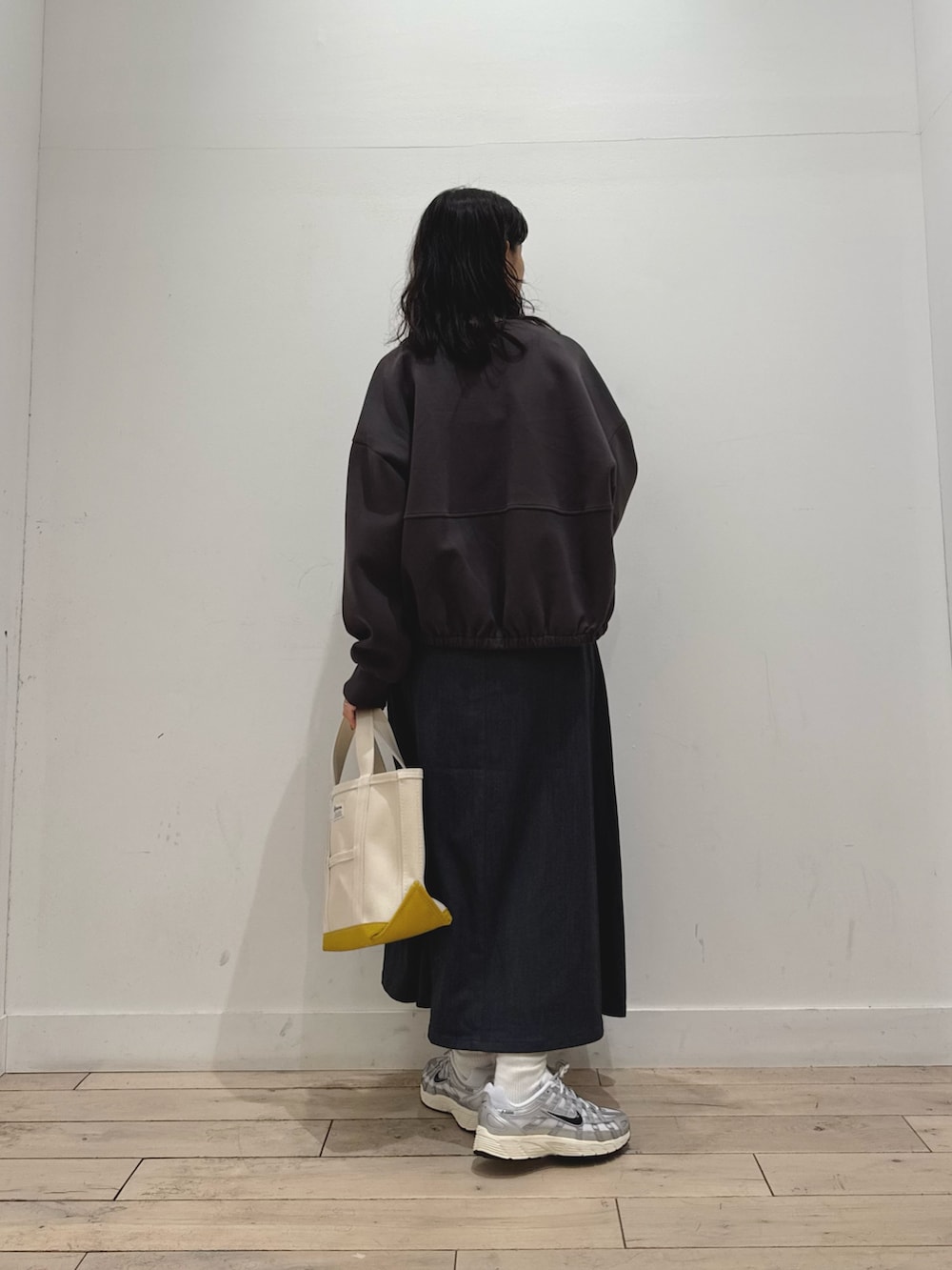 ホワイト系のTシャツ/カットソー、グレー系のスカート、グレー系のカーディガン/ボレロを着用したレディースの秋コーディネートの3枚目の写真