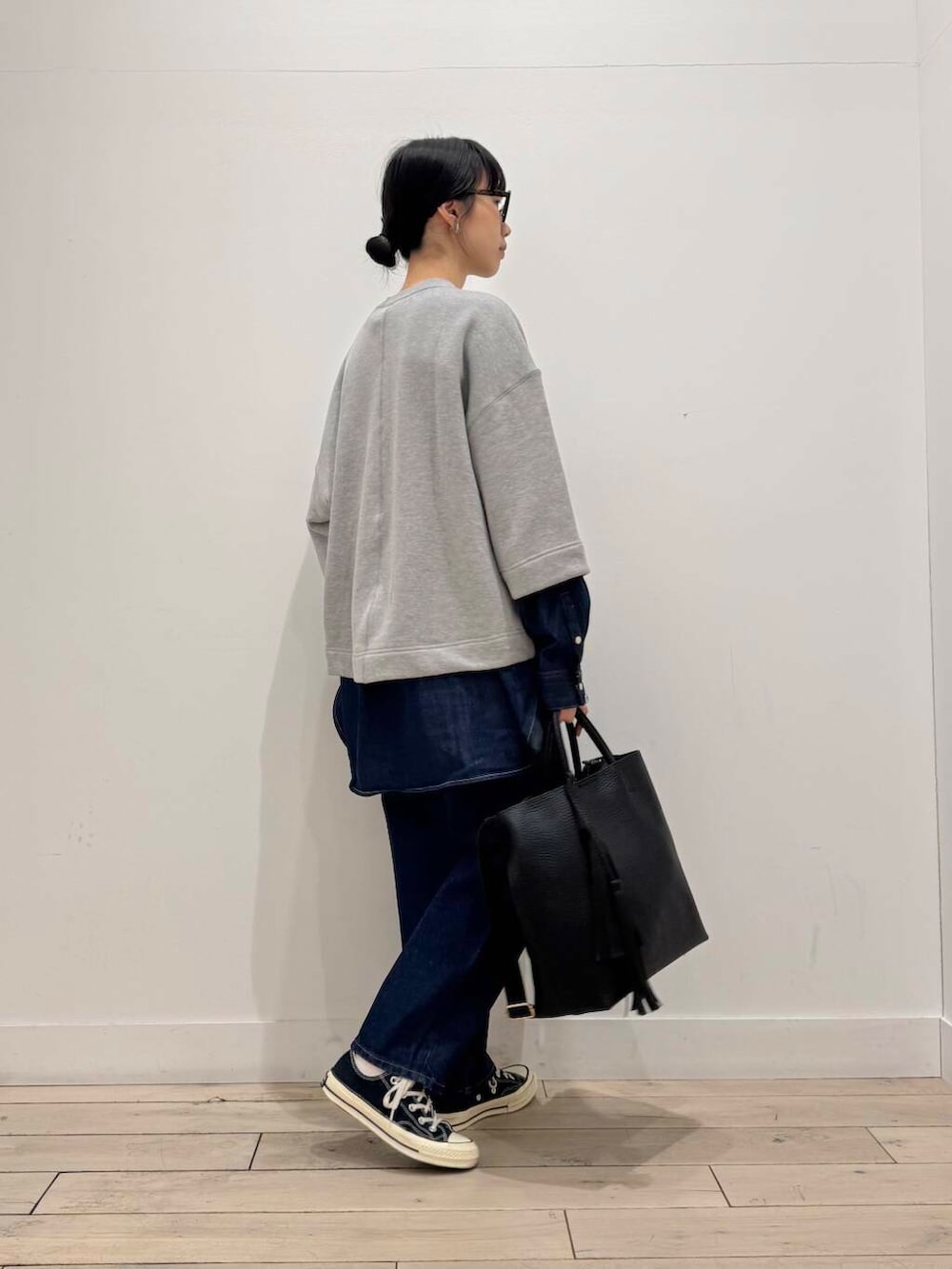 ブルー系のデニムパンツ、ブラック系のトートバッグ、ブルー系のシャツ/ブラウスを着用したレディースの春コーディネートの2枚目の写真