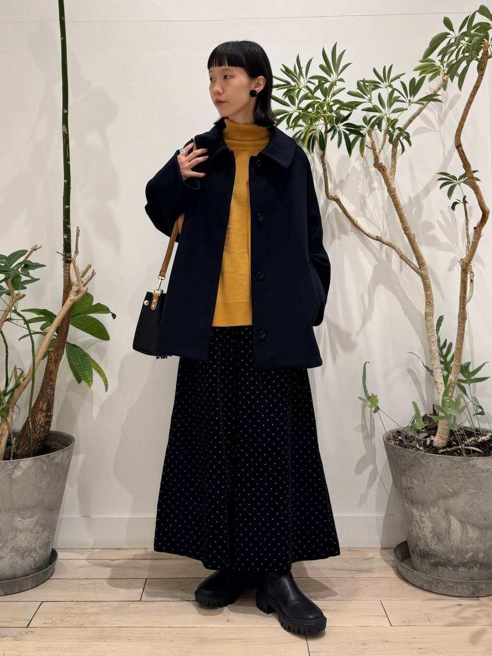 ブラック系のトートバッグ、イエロー系のニット/セーター、ブルー系のその他アウターを着用したレディースの秋コーディネートの5枚目の写真