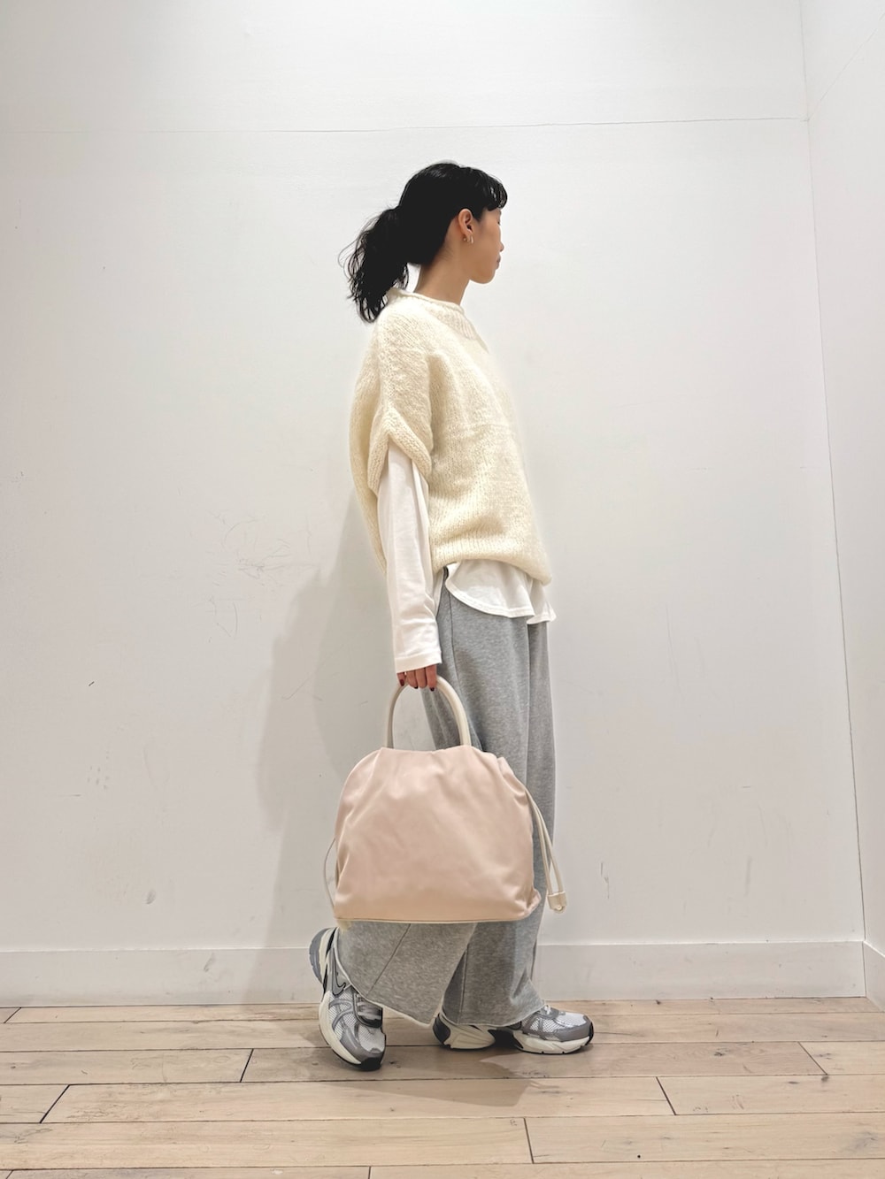 シルバー系のスニーカー、ホワイト系のショルダーバッグ、ホワイト系のニット/セーターを着用したレディースの秋コーディネートの2枚目の写真