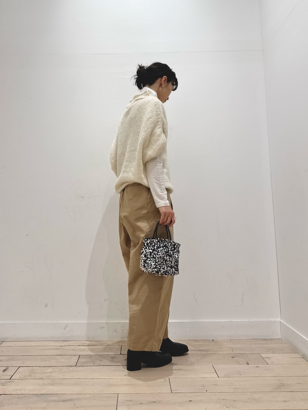 ホワイト系のTシャツ/カットソー、ホワイト系のニット/セーター、シルバー系のショルダーバッグを着用したレディースの秋コーディネートの2枚目の写真