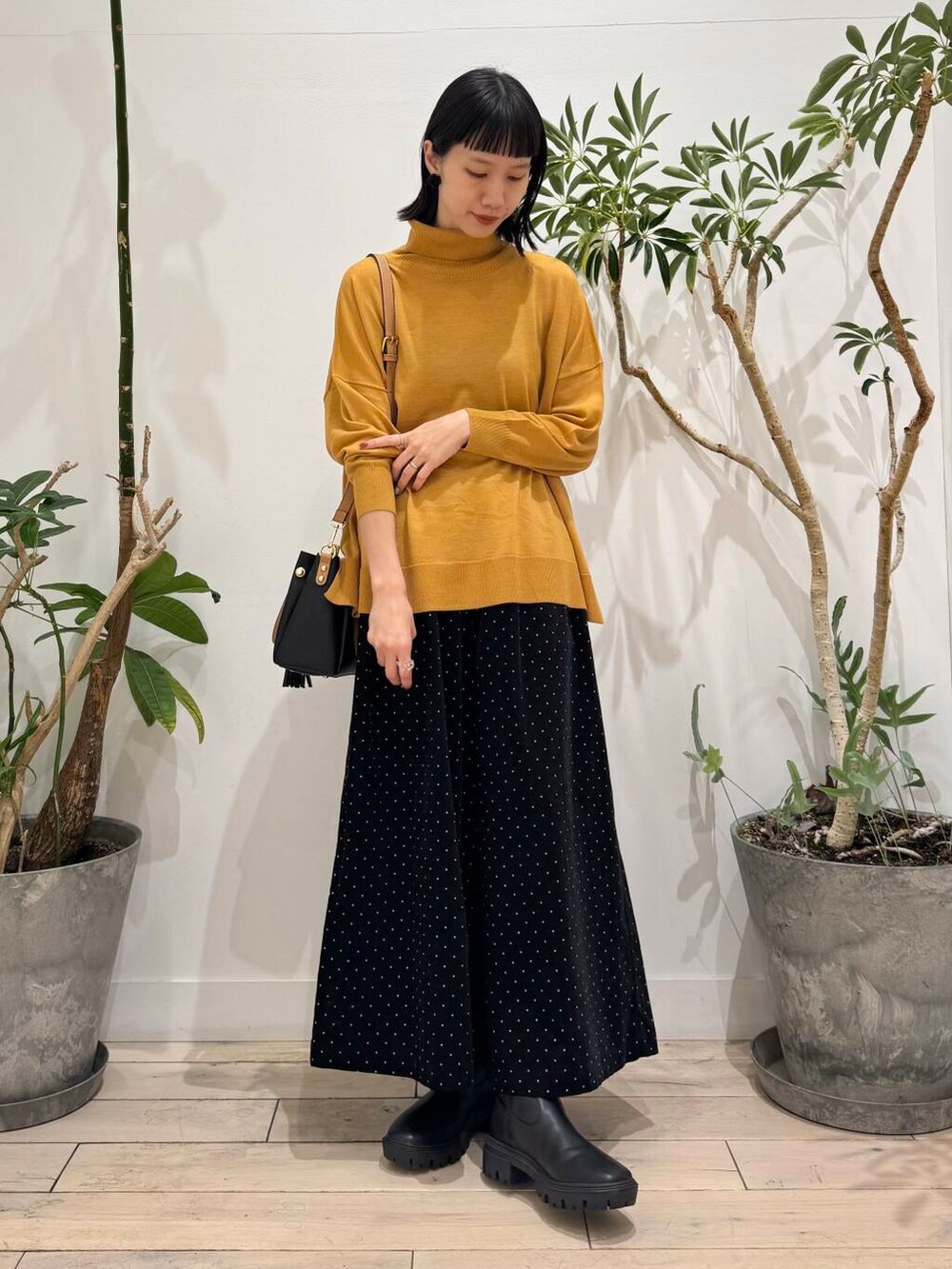 ブラック系のトートバッグ、イエロー系のニット/セーター、ブルー系のその他アウターを着用したレディースの秋コーディネートの6枚目の写真
