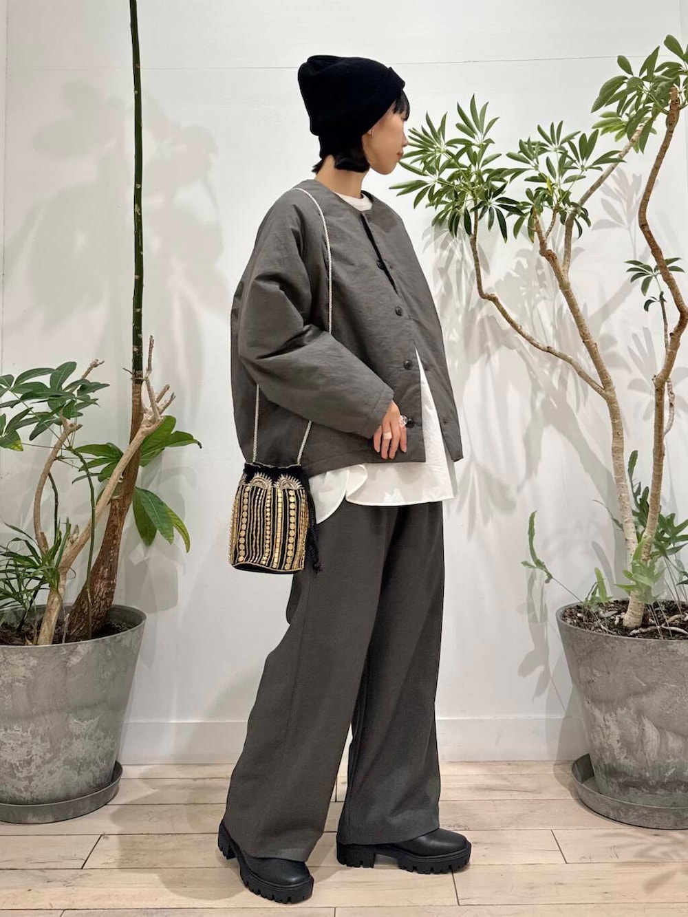 ブラック系のショルダーバッグ、ブラック系のブーツ、グレー系のその他パンツを着用したレディースの秋コーディネートの2枚目の写真