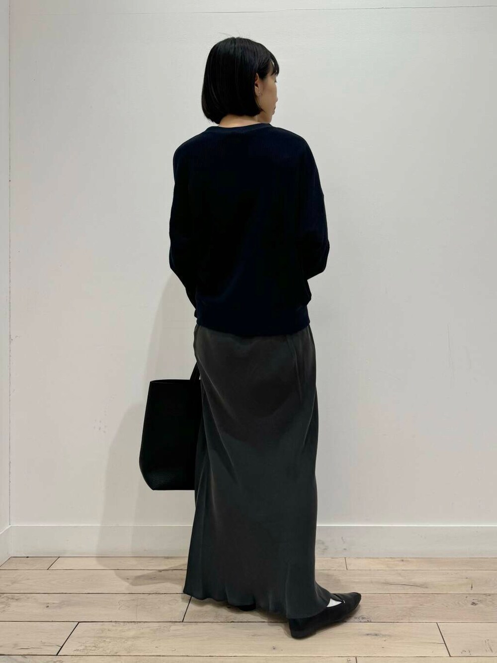 ブラック系のローファー、ブラック系のトートバッグ、ブルー系のTシャツ/カットソーを着用したレディースの夏コーディネートの3枚目の写真