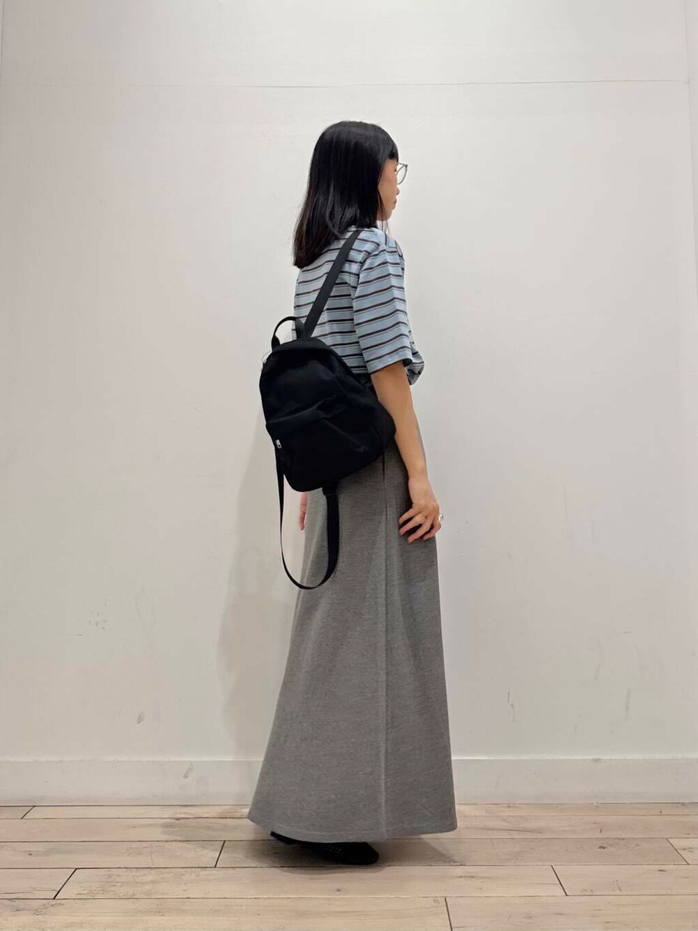 ブラック系のバックパック/リュック、グレー系のスカート、ブラック系のバレエシューズを着用したレディースの夏コーディネートの3枚目の写真