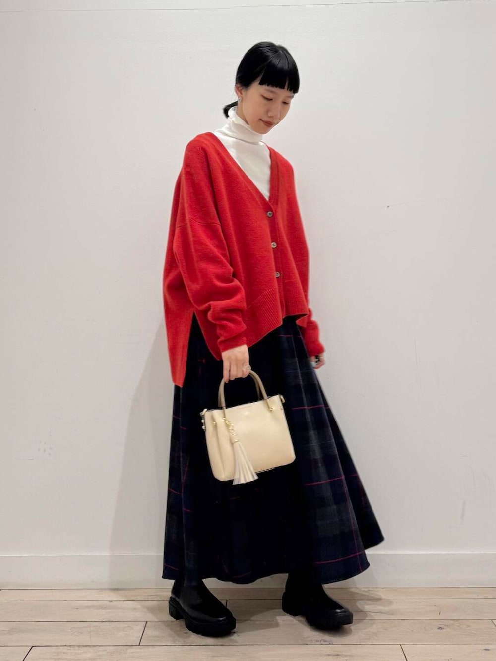 ホワイト系のトートバッグ、ブラック系のノーカラーコート、ブラック系のブーツを着用したレディースの冬コーディネートの6枚目の写真