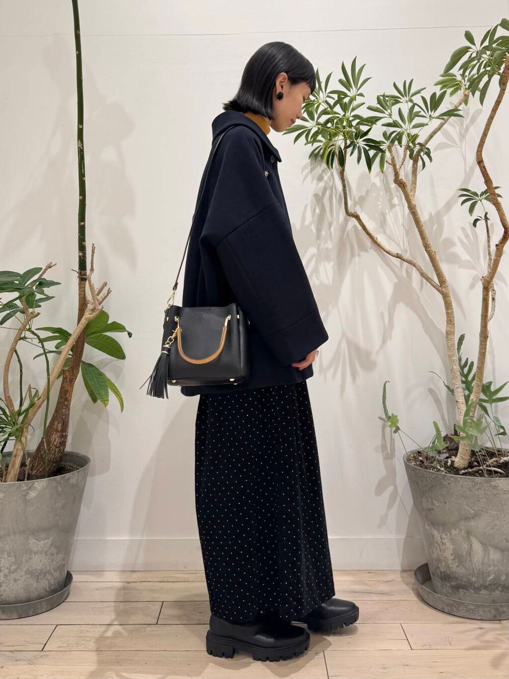 ブラック系のトートバッグ、イエロー系のニット/セーター、ブルー系のその他アウターを着用したレディースの秋コーディネートの4枚目の写真