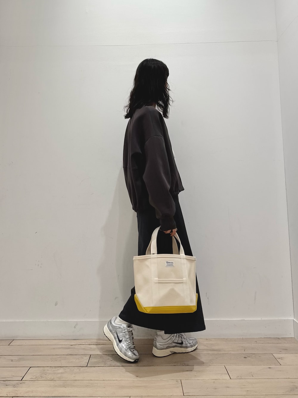 ホワイト系のTシャツ/カットソー、グレー系のスカート、グレー系のカーディガン/ボレロを着用したレディースの秋コーディネートの2枚目の写真