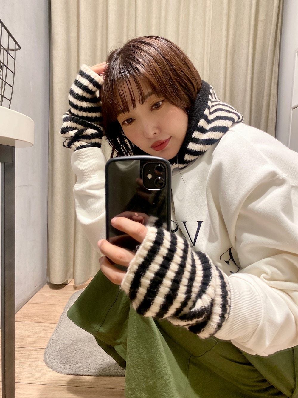 ホワイト系のスウェット、ブラック系のブーツ、その他のアームカバーを着用したレディースの秋コーディネートの2枚目の写真