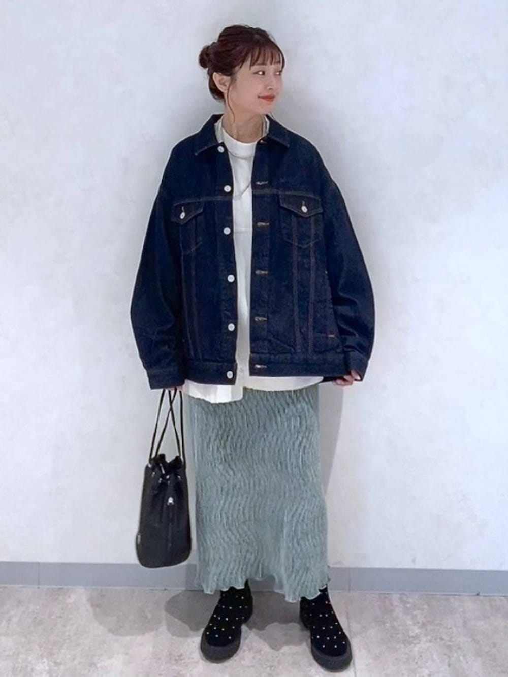 ブルー系のデニムジャケット、グリーン系のスカート、その他のブーツを着用したレディースの秋コーディネートの4枚目の写真