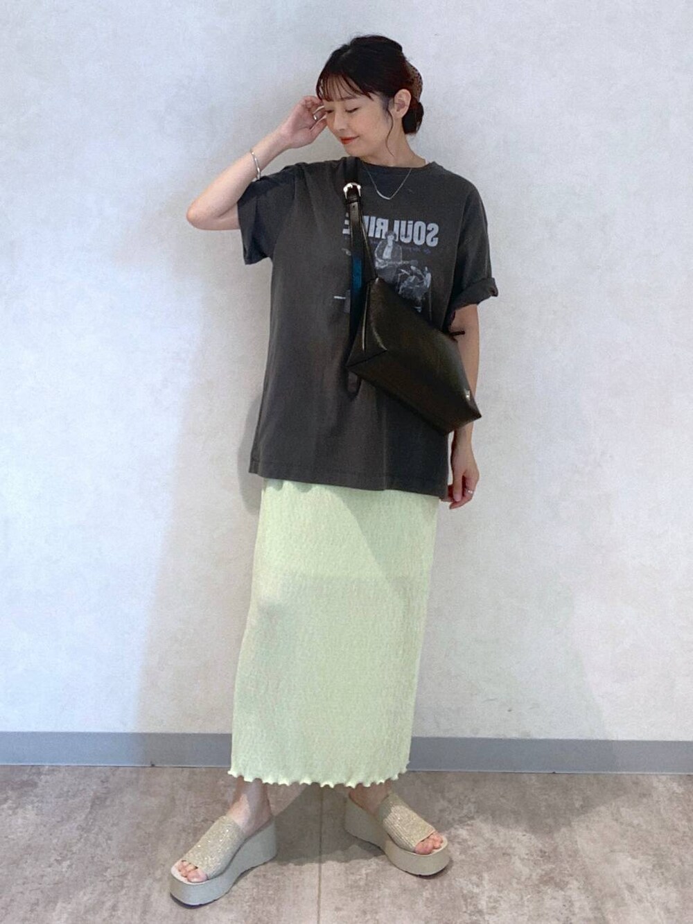 ホワイト系のサンダル、ブラック系のショルダーバッグ、グレー系のTシャツ/カットソーを着用したレディースの春コーディネートの2枚目の写真