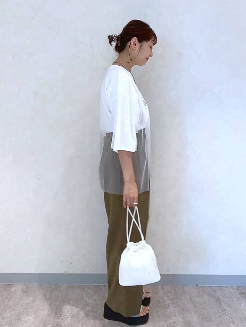 シルバー系のサンダル、ホワイト系のショルダーバッグ、ブラウン系のスラックスを着用したレディースの夏コーディネートの3枚目の写真
