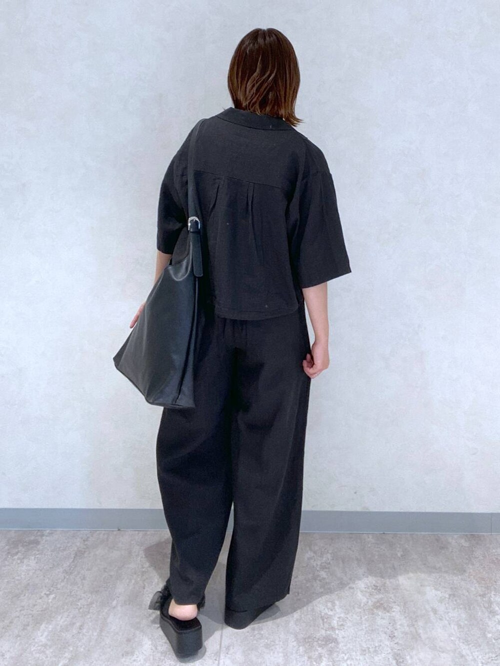 ブラック系のサンダル、ブラック系のショルダーバッグ、ブルー系のタンクトップを着用したレディースの春コーディネートの5枚目の写真