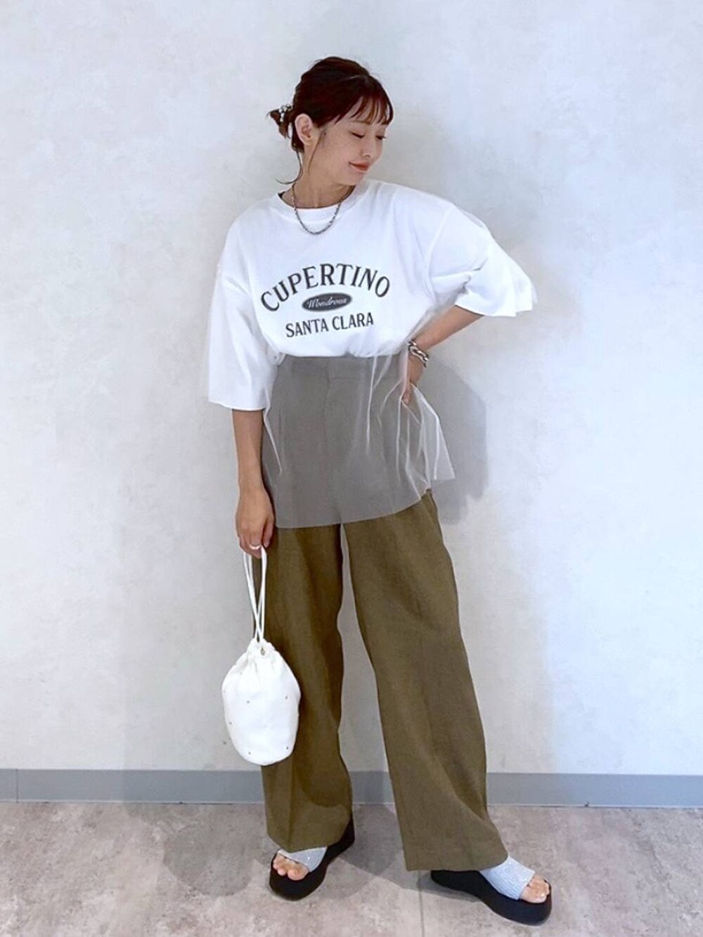 シルバー系のサンダル、ホワイト系のショルダーバッグ、ブラウン系のスラックスを着用したレディースの夏コーディネートの4枚目の写真