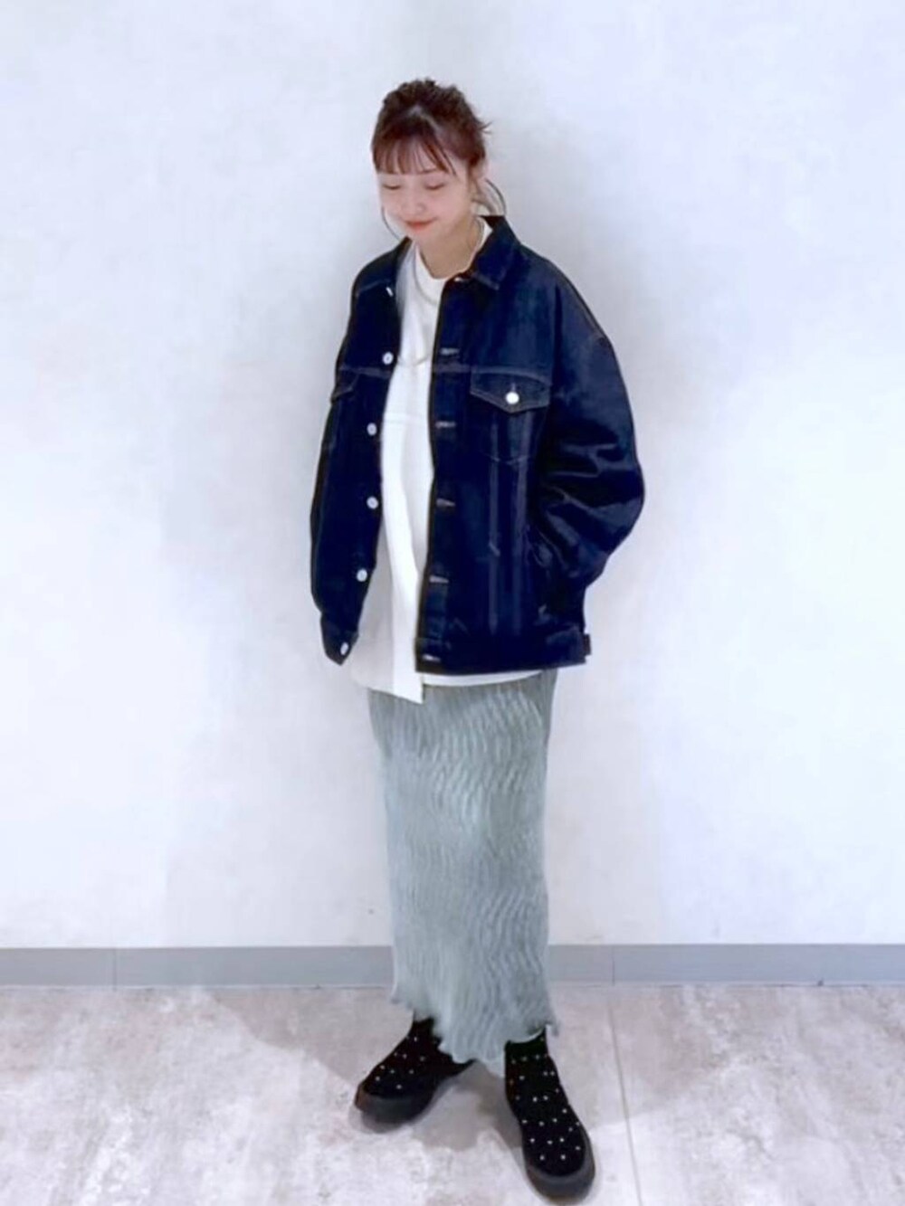 ブルー系のデニムジャケット、グリーン系のスカート、その他のブーツを着用したレディースの秋コーディネートの3枚目の写真