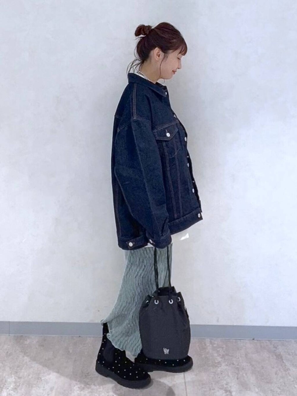 ブルー系のデニムジャケット、グリーン系のスカート、その他のブーツを着用したレディースの秋コーディネートの2枚目の写真