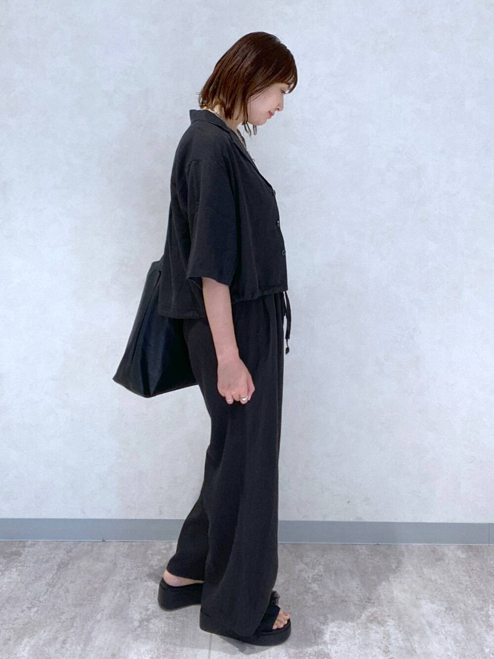 ブラック系のサンダル、ブラック系のショルダーバッグ、ブルー系のタンクトップを着用したレディースの春コーディネートの3枚目の写真