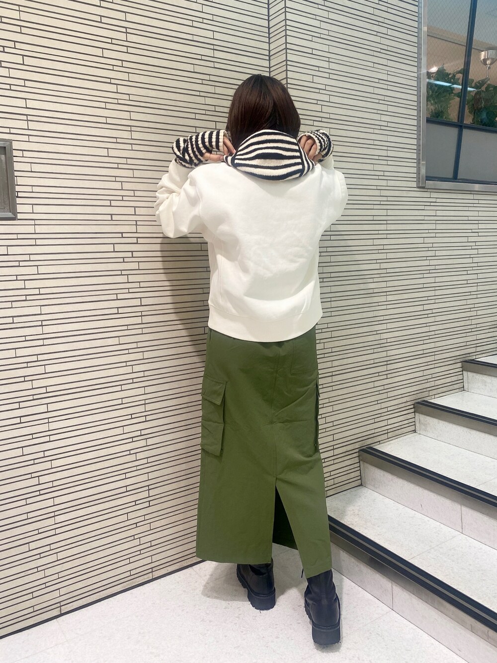 ホワイト系のスウェット、ブラック系のブーツ、その他のアームカバーを着用したレディースの秋コーディネートの3枚目の写真