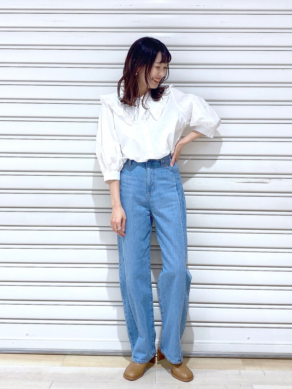 ブルー系のデニムパンツ、ブラック系のサンダルを着用したレディースの春コーディネートの2枚目の写真